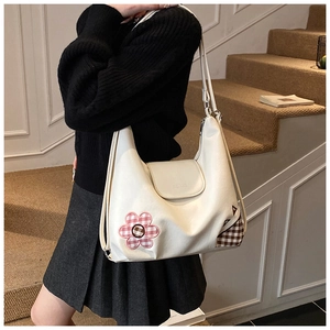 Detail of off-white PU leather tote bag with floral embroidery and brown plaid patch