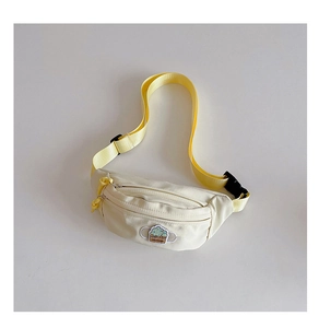 Détail du sac de poitrine en nylon blanc avec sangle jaune et broderie d'arbre