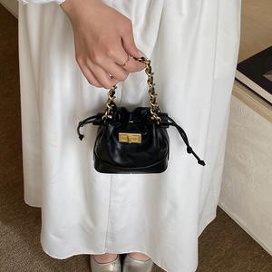 Mini sac seau noir matelassé avec anse chaîne dorée et fermeture à cordon pour femme