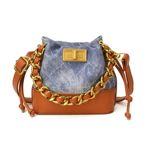 Mini sac seau bicolore en denim matelassé bleu et cuir synthétique marron