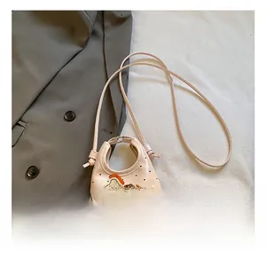 Dettaglio mini borsa rosa con stampa a cuori e ricamo a cavallo su blazer grigio