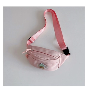 Détail du sac de poitrine rose en nylon pour enfants avec bandoulière et écusson brodé