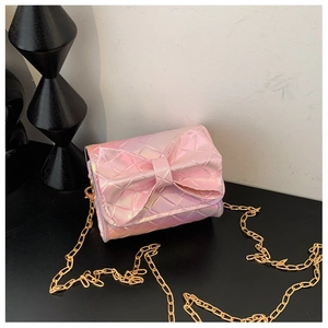 Macro shot of mini holographic pink crossbody bag with quilted bow and gold chain