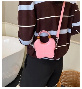 Detail of pink star-shaped leather bucket bag with wooden beads and crossbody strap