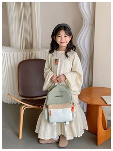 Detail of color-block kids backpack with orange drawstring and durable fabric
