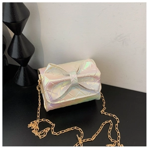 Macro shot of iridescent quilted mini bag with a large bow and gold metal chain