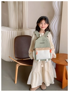 Detail view of stylish kids backpack with beige and sage green color-blocking design