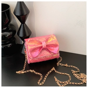 Detailed view of pink metallic quilted crossbody bag with large bow and gold chain strap