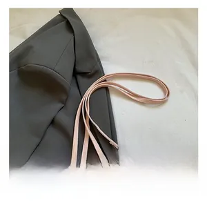 Detailed shot of pink leather bag featuring silver metal rivets and adjustable shoulder strap