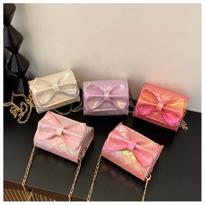 Close-up of holographic bow mini bags with diamond quilting and gold chain straps