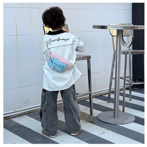 Détail d'un sac de poitrine enfant tricolore avec sangle réglable porté sur le dos