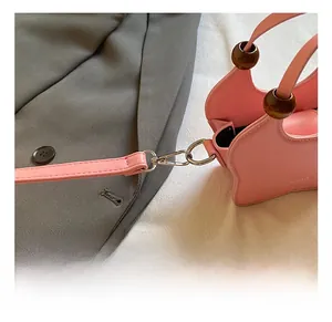 Detail of silver metal swivel hook and pink PU leather strap on a chic handbag