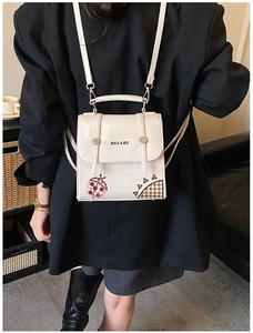 Close-up of white PU leather kids backpack featuring ladybug print and adjustable straps