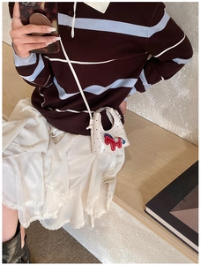 Gros plan d'un mini sac bandoulière blanc à pois avec broderie de poney rouge