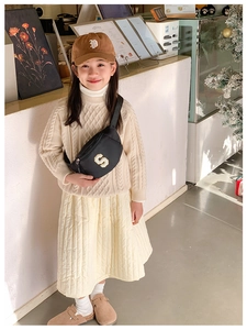 Kid stylish black crossbody chest bag paired with casual autumn knitted outfit