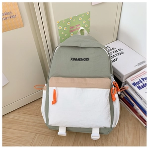 Detail view of a color-block school backpack with pockets and brand logo in a cozy setting