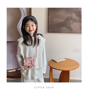 Detailed macro view of a pink mini cylindrical PU leather shoulder bag for kids