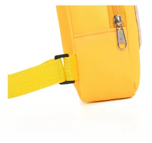 Détail du sac en nylon jaune montrant les coutures, le zip argenté et la boucle noire