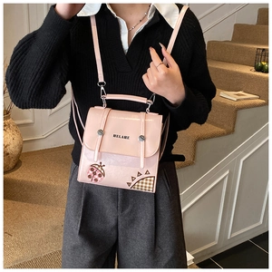 Pink ladybug crossbody bag with HELAHE text and adjustable shoulder strap worn by a model