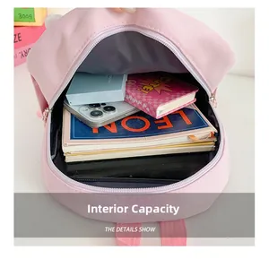 Pink cartoon backpack interior view showing storage space for books and phone