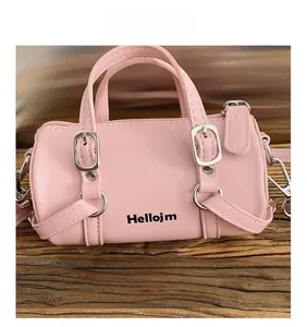 Detailed close-up of a pink cylindrical mini bag featuring twin handles and black lettering