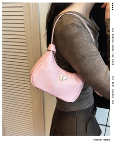 Détail du sac à main rose pour enfant avec logo papillon en métal et finition en similicuir