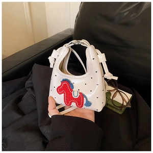 Détail macro du mini sac blanc à pois avec broderie cheval rouge et finition cuir lisse