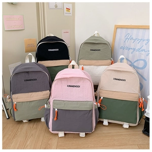Detailed group view of colorful patchwork school backpacks with vibrant orange drawstring cords