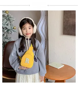 Enfant portant un sac bandoulière en toile jaune vif avec broderie de la lettre R