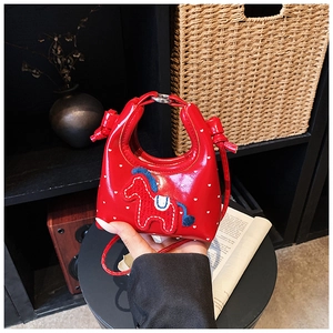 Détail du mini sac rouge à motifs cœurs avec écusson poney et poignée métallique