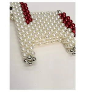 Detail of handmade beaded horse-shaped bag showing ivory pearls and red accents