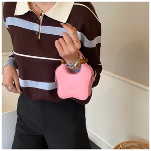 Detailed view of pink star-shaped bag with dark wooden bead handle and logo