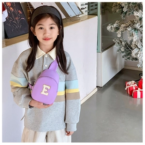 Detail view of purple crossbody chest bag for kids with sequined letter E patch