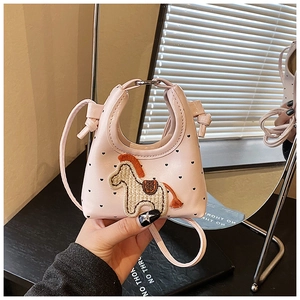 Vue détaillée du sac rose pour enfant avec motifs de cœurs noirs et écusson de poney