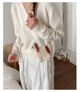 Detail of handmade bead woven mini horse crossbody bag with elegant pearl chain strap