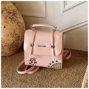 Pink ladybug backpack detail with HELAHE lettering and shiny faux leather texture