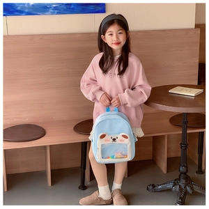 Detail of light blue kids backpack featuring a cute white bear and transparent PVC pocket