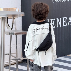 Vue arrière d'un enfant portant un sac de poitrine tendance en toile noire pour le sport