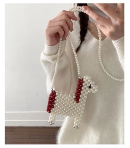 Détail du sac bandoulière alpaga fait main en perles blanches avec accents rouges