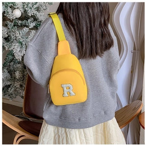 Vue détaillée de dos d'un sac bandoulière jaune pour enfant avec broderie lettre R