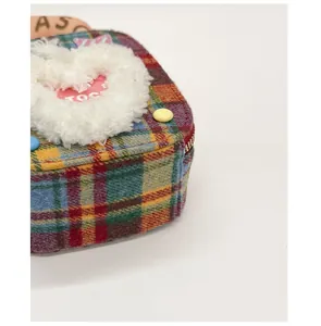 Gros plan du sac à main en tissu écossais coloré avec un grand cœur en peluche et fermeture éclair