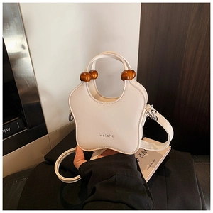 Detail of star-shaped cream PU leather shoulder bag with decorative wooden beads