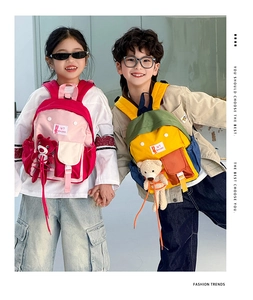 Detail of color-block kids backpack with cute 3D teddy bear doll and durable canvas texture