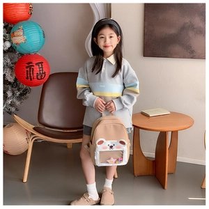 Detail of kindergarten backpack featuring a transparent window with sequins and bear ears