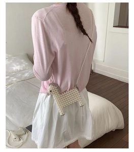 Detail of a handmade mini alpaca pearl shoulder bag shown on a child model