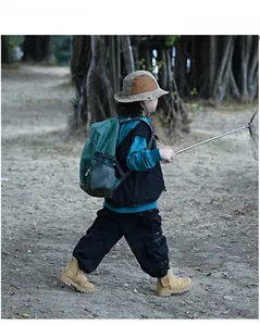 Outdoor scene of a kids hiking backpack styled with tactical vest and utility gear