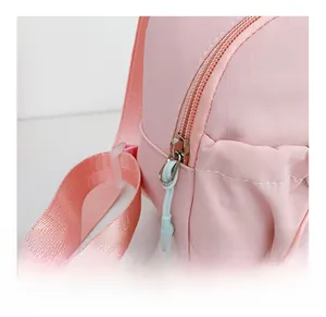 Detailed close-up of pink nylon kids crossbody bag with smooth zipper and blue puller
