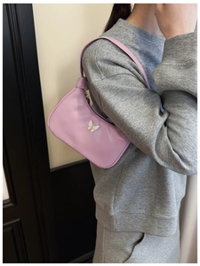 Détail du sac à bandoulière lilas pour enfants avec papillon porté par un mannequin