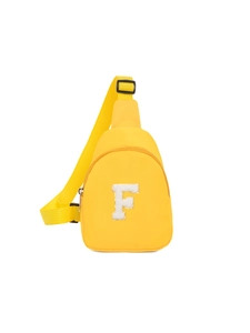 Détail d'un sac de poitrine en nylon jaune vif avec un écusson lettre F en peluche
