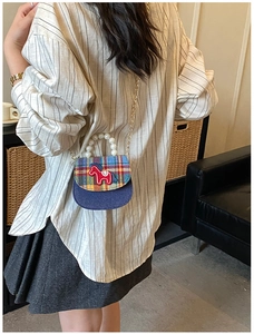 Detailed shot of kids plaid crossbody bag with pearl handle and pony embroidery